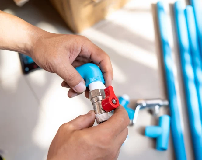 plumber putting teflon thread tape on the thread preparing to connect to pvc pipe at home free photo